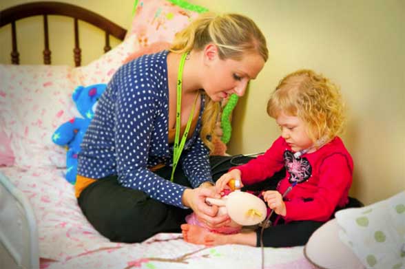 Pediatric Home Service nurse providing an in-home patient health care to a little girl