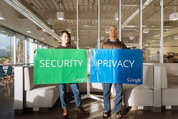 Two Google team members holding up a green security flag and blue privacy flag